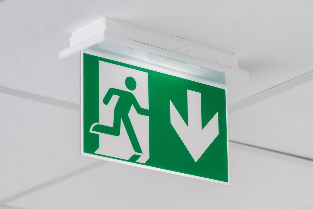 A,Modern,Illuminated,Emergency,Exit,Sign,With,A,Green,Background